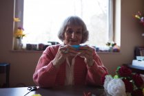 Mujer mayor haciendo trabajo artesanal en un hogar de ancianos - foto de stock