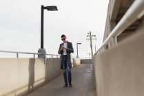Продуманий людина за допомогою мобільного телефону на мосту — стокове фото