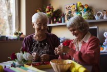 Duas mulheres seniores fazendo flor artificial em casa de repouso — Fotografia de Stock