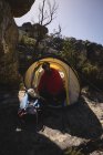 Wanderer in Decke gehüllt sitzt an einem sonnigen Tag im Zelt — Stockfoto