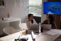 Collègues d'affaires interagissant entre eux dans la salle de conférence au bureau — Photo de stock