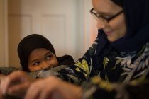 Мусульманская мать и дочь улыбаются дома — стоковое фото
