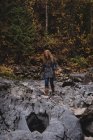 Rothaarige Frau geht auf den nassen Felsen — Stockfoto