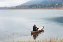 Людина веслові каное в silent річка — стокове фото
