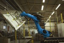 Синий роботизированный станок на заводе за работой — стоковое фото