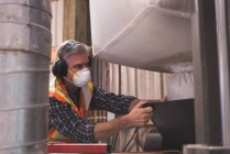 Homem em vestuário de trabalho de proteção refino de grãos na fábrica — Fotografia de Stock