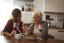 Senior woman and daughter eating omelet and wine for breakfast — Stock Photo