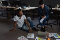 Geschäftsleute mit Laptop diskutieren über Dokumente im Büro. — Stockfoto