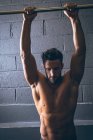 М'язистий чоловік вправляється на витяжці в фітнес-студії — стокове фото