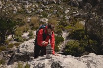 Escursionista che fa cairn roccia per segnare percorso in una giornata di sole — Foto stock