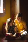 Дочка з матір'ю читає книгу в спальні вдома — стокове фото