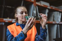 Trabalhadora verificando placa de circuito na fábrica — Fotografia de Stock