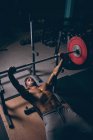 Soffitto di uomo muscoloso che si allena con il bilanciere nella sala fitness — Foto stock