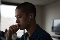 Молода людина слухає музику на навушниках вдома — стокове фото
