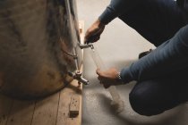 Arbeiter füllt in Fabrik alkoholisches Getränk in gläsernen Messzylinder — Stockfoto