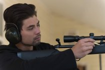 Крупним планом людина заряджає кулю в снайперську гвинтівку — стокове фото