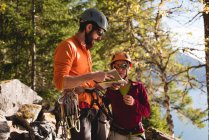 Hiker couple looking at map near mountain — Stock Photo