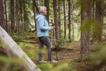 Side view of mature woman standing in the forest — Stock Photo