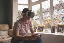 Чоловік грає у відеоігри в гарнітурі віртуальної реальності вдома . — стокове фото