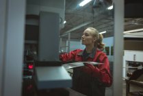 Жінка-працівник перевіряє машину на заводі — стокове фото