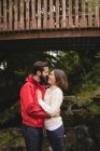 Affectionate couple standing under footbridge — Stock Photo