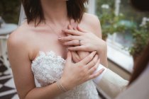 Primer plano del novio colocando su mano en el pecho de las novias - foto de stock