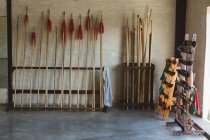 Poteaux longs et lances de kung fu disposées sur des supports dans un studio d'arts martiaux . — Photo de stock