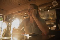 Чоловік розмовляє по мобільному телефону, маючи каву в кафетерії — стокове фото