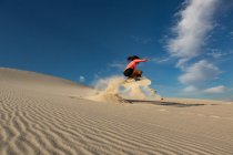 Sandboard femme sur dune de sable au désert — Photo de stock