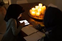 Donna musulmana aiutare la figlia con i compiti a casa — Foto stock
