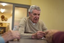 Senior man playing cards at nursing home — Stock Photo