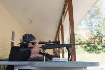 Человек, целящийся снайперской винтовкой в мишень в солнечный день — стоковое фото