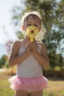 Cute girl playing with bubble wand in park — Stock Photo