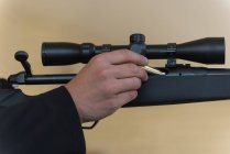 Close-up of man loading bullet into sniper rifle — Stock Photo