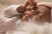 Neugeborenes reibt Augen auf flauschige Decke. — Stockfoto