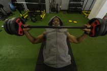 Senior man lifting barbell in fitness studio. — Stock Photo
