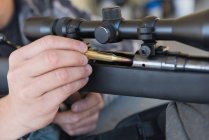 Close-up of man loading bullet into sniper rifle — Stock Photo
