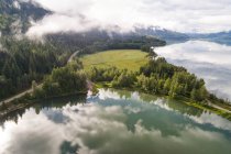 Wolken, die sich im Fluss in der Nähe der Waldlandschaft spiegeln — Stockfoto
