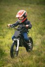 Close-up of kid rider riding a bike in garden — Stock Photo