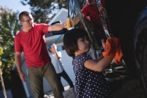 Father and daughter washing car with sponge and duster outside garage — Stock Photo