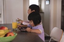 Брат и сестра завтракают за столом на кухне — стоковое фото