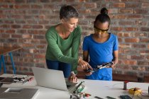 Mother explaining daughter about circuit board in office. — Stock Photo