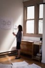 Деловая женщина проверяет чертежи на стене в офисе . — стоковое фото