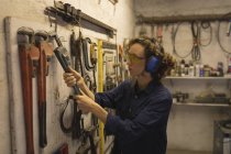 Женщина-работница держит гаечный ключ в мастерской — стоковое фото