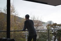 Junger Mann steht zu Hause auf dem Balkon — Stockfoto