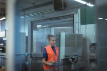 Female worker operating machine in factory — Stock Photo