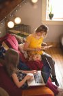 Сім'я на дивані з використанням мультимедійних пристроїв вдома — стокове фото