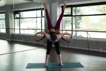 Mulheres aptas a praticar acroioga no estúdio de fitness . — Fotografia de Stock
