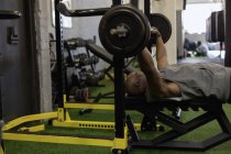 Homme senior levant haltère dans un studio de fitness . — Photo de stock