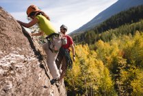 Determined rock climbers reaching on the cliff top — Stock Photo